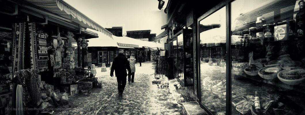 Abadžiluk street in Baščaršija — a narrow stone-paved Ottoman bazaar lane with low shopfronts on both sides.