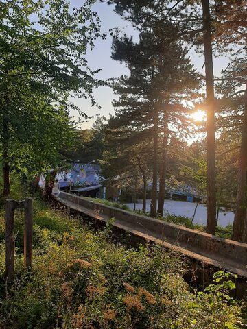 The lower section of the Sarajevo Olympic bobsled track, closer to the finish house, seen in evening August light.