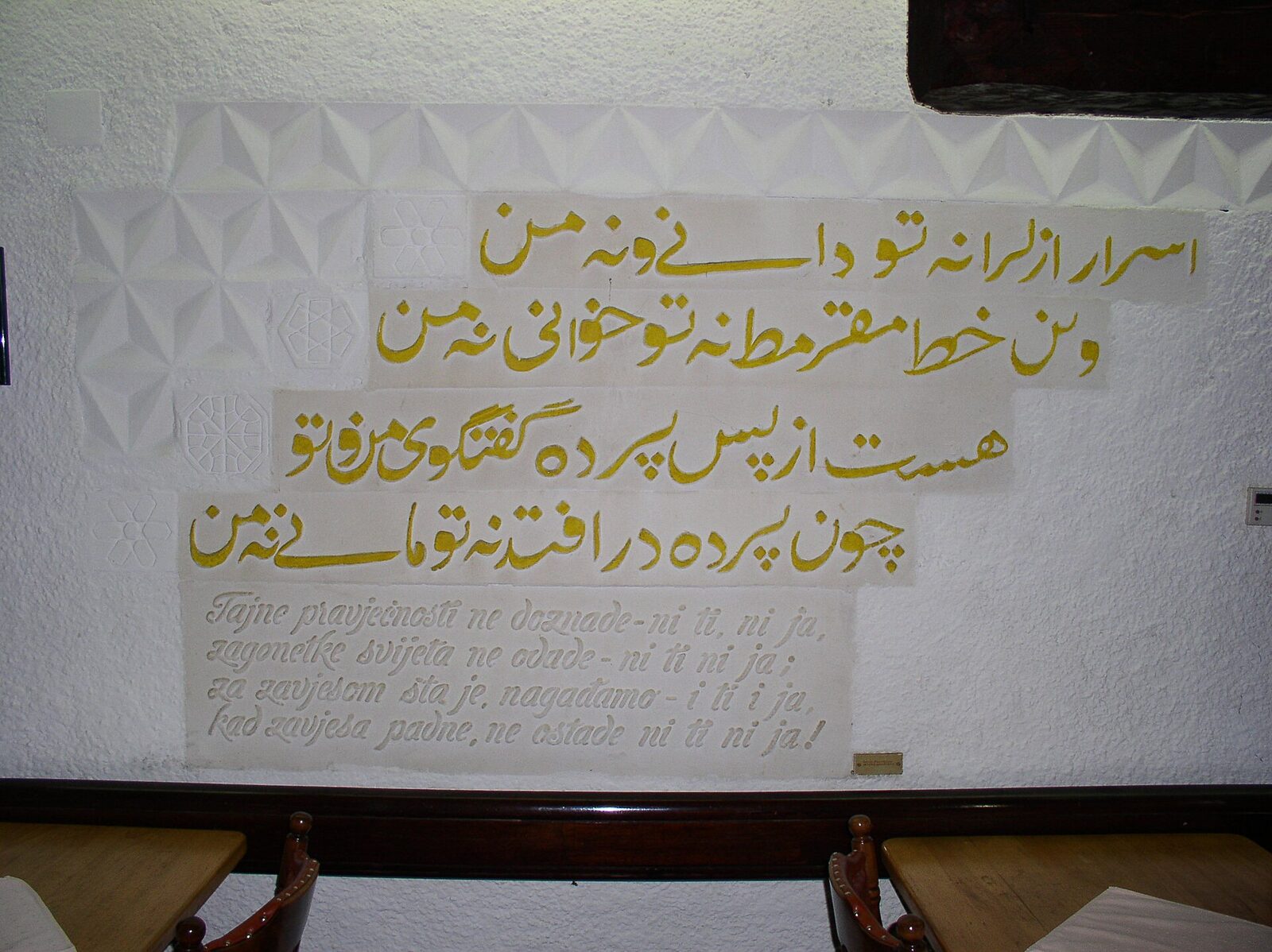 A Persian calligraphy inscription from a poem by Omar Khayyám carved into a wooden panel in the arcade gallery of Morića Han in Sarajevo.