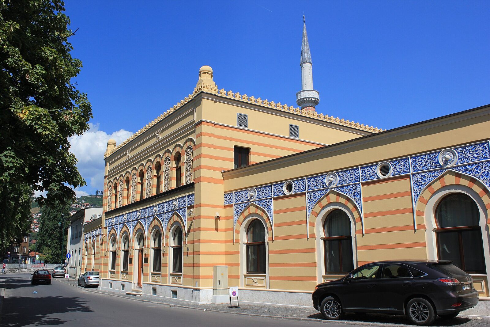 Corner view of the Isa-Begov Hamam in Sarajevo, with the minaret of the Emperor's Mosque visible above the roofline.