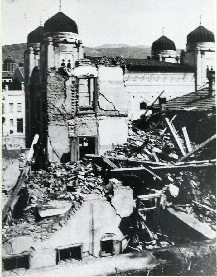 Bombed houses in Sarajevo photographed on 7 April 1941, with a synagogue standing behind the ruins — the German air raids that opened the invasion of Yugoslavia.