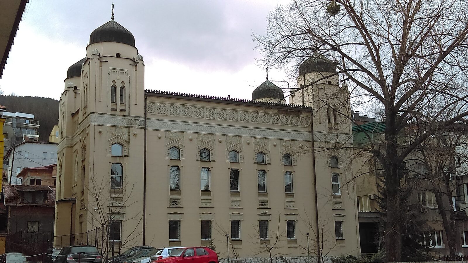 The Ashkenazi Synagogue in Sarajevo — a large yellow-façade building with four onion-domed corner turrets in the Moorish Revival style, designed by Karel Pařík and opened in 1902 to serve the Ashkenazi Jewish community that had arrived under Habsburg rule.