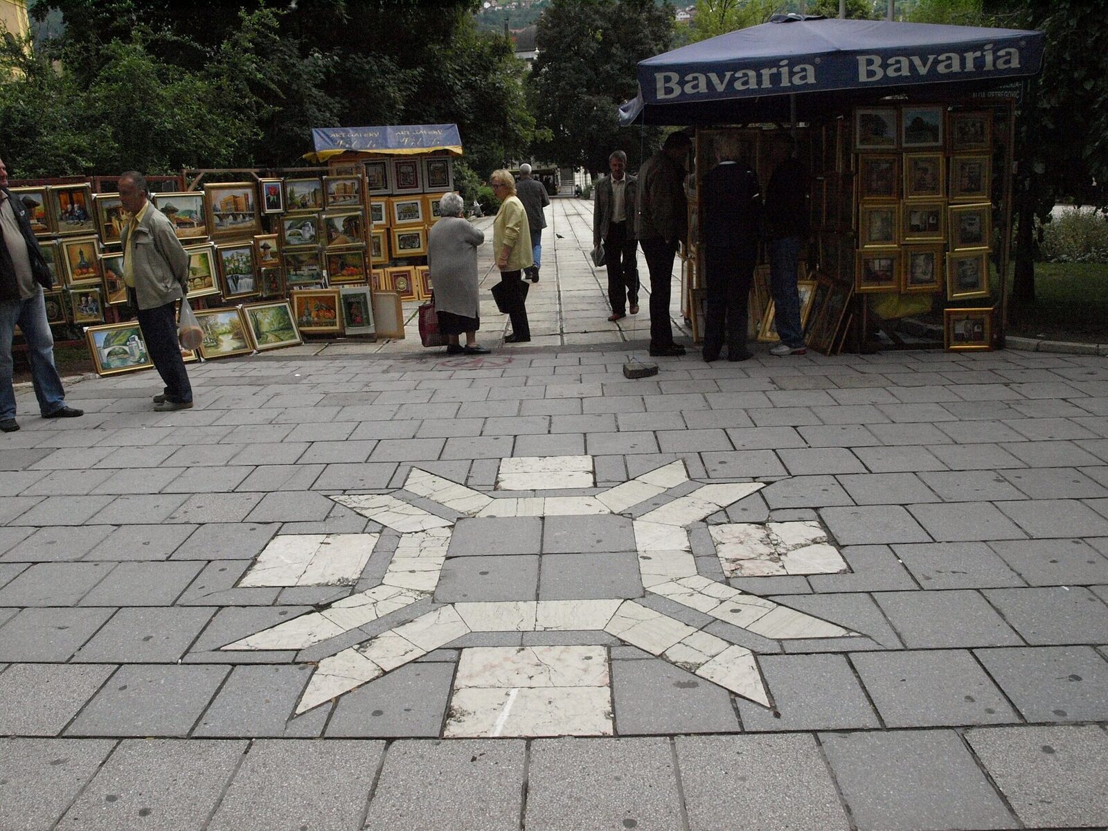The 1984 Winter Olympics snowflake logo displayed on a building in Sarajevo, a stylised geometric snowflake in the characteristic orange-and-white Olympic branding.