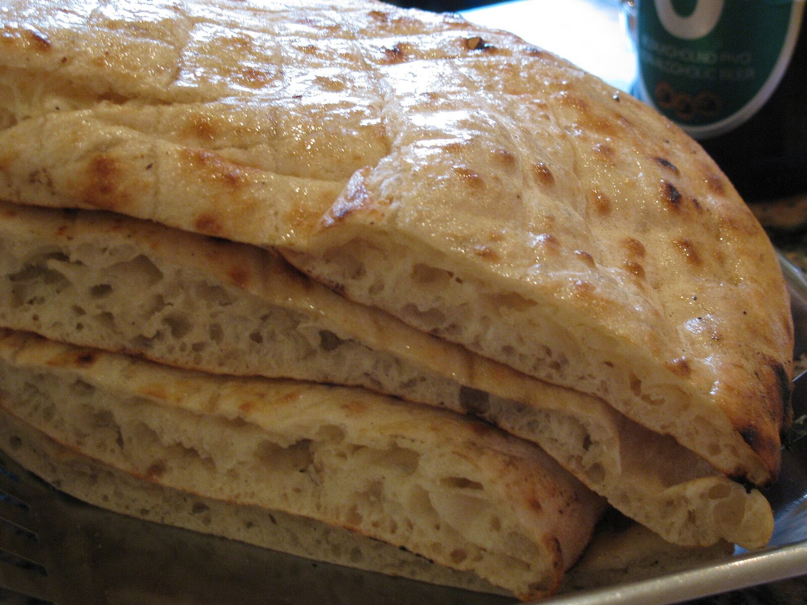 A stack of fresh Sarajevski somun — the round wood-fired flatbread that Sarajevo's traditional pekaras, including Pekara Imaret, bake in under a minute in a hot brick oven.