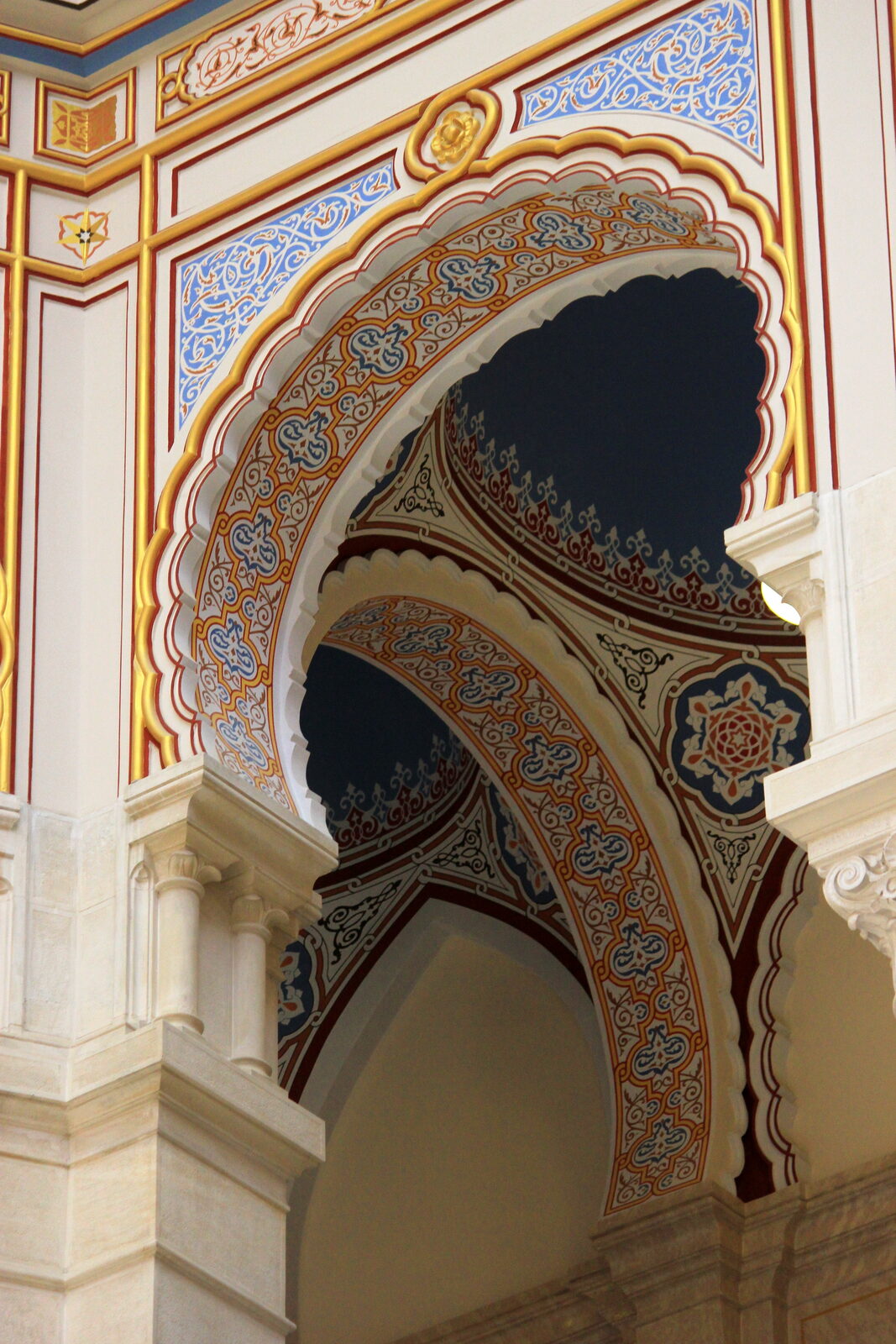 Looking up from the floor of Sarajevo's Vijećnica into the octagonal stained-glass dome — the interior compositional device the five northern-Bosnia siblings share in reduced form.