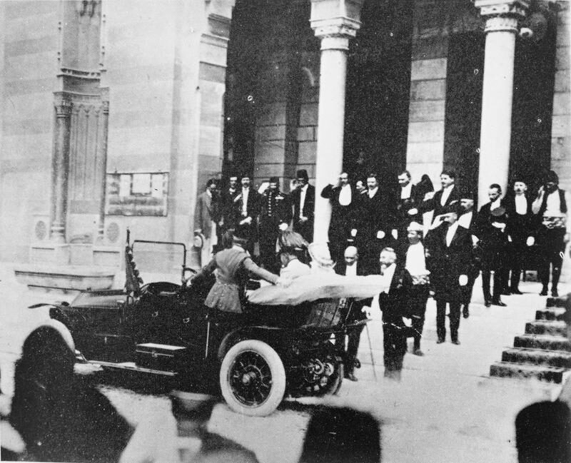 Archduke Franz Ferdinand of Austria and his wife Sophie Chotek getting into an open Gräf and Stift touring car in Sarajevo on the morning of 28 June 1914, surrounded by officials in uniform. The car would stall at the Latin Bridge corner less than an hour later.